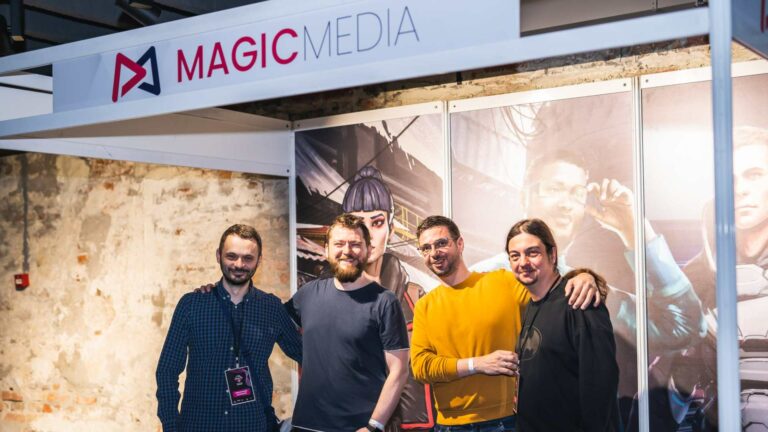 Team members from Magic Media smiling for a group photo at their exhibition stand, showcasing their innovative contributions to the gaming industry, at the USF Gaming Fair event.