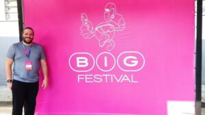 A Magic Media employee stands in front of a bright pink 'BIG Festival' banner, showcasing the lively atmosphere of the event.