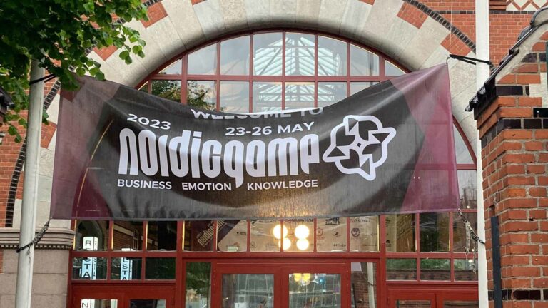 Magic Media at Nordic Games, a banner for the 2023 Nordic Game conference, hanging over a red doorway.